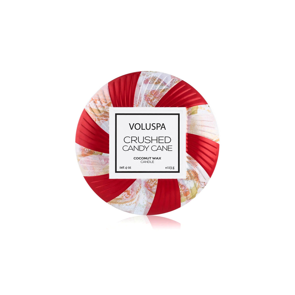 The top of a round coconut wax candle in a red and white striped candy cane design, featuring a white label in the center that reads 'VOLUSPA CRUSHED CANDY CANE'.