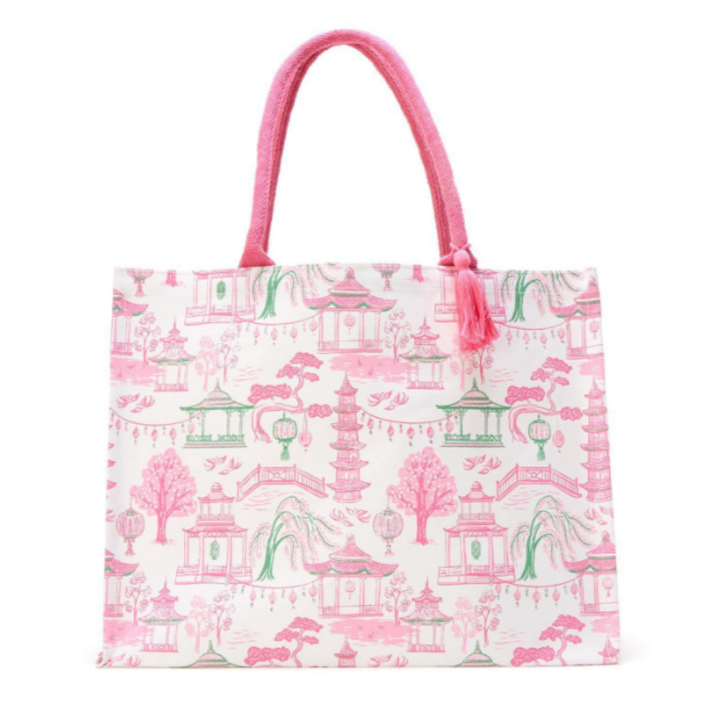 A tote bag with a pink and green garden-themed toile pattern on a white background, featuring pink fabric handles and a tassel.