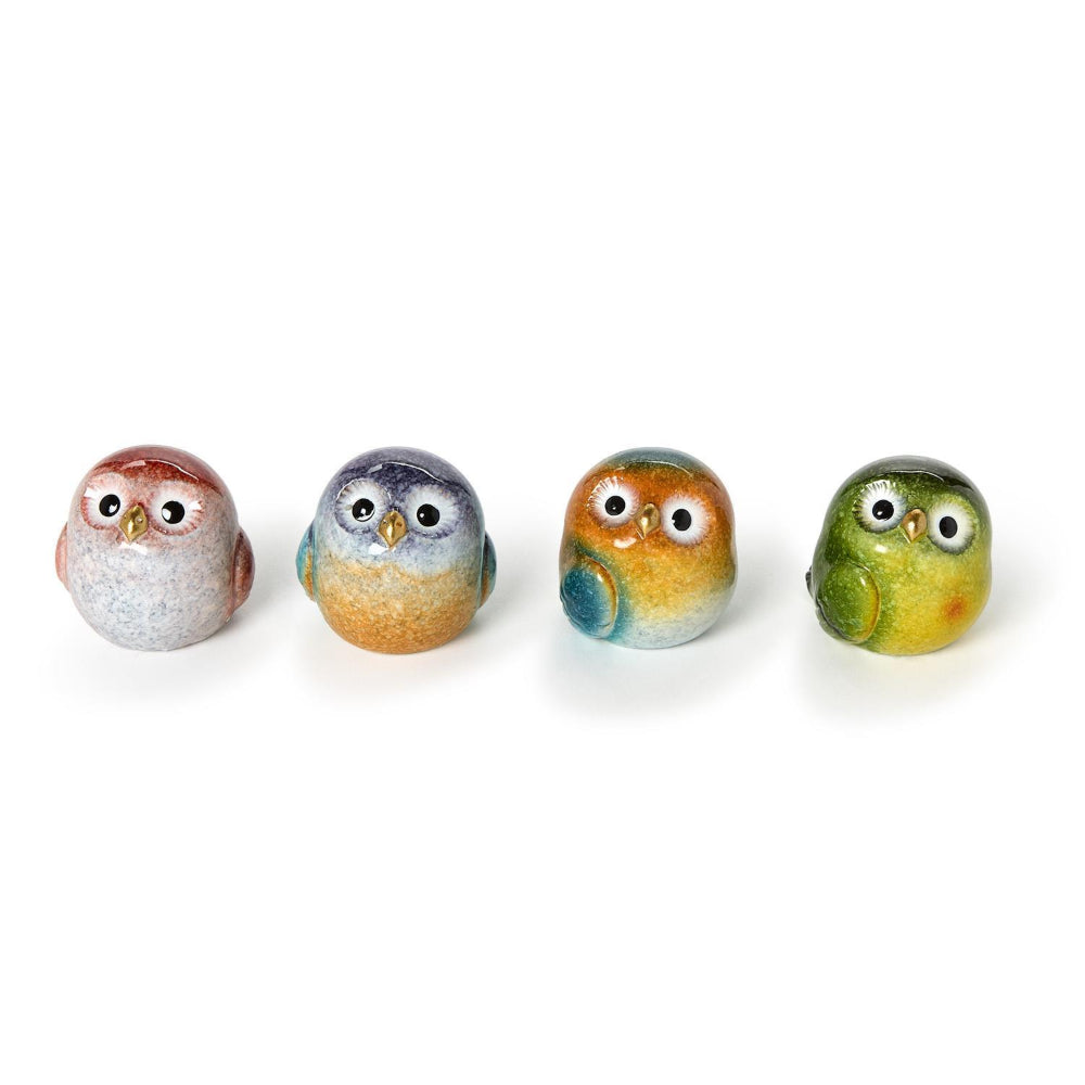 Four small ceramic owl figurines with different color patterns on a white background