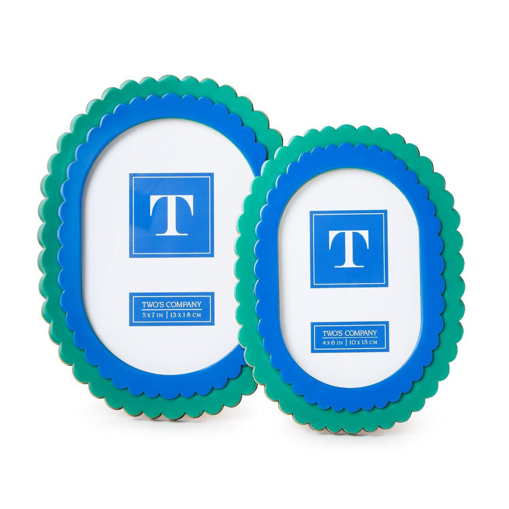 Two scalloped picture frames with blue inner borders and green outer borders, shown on a white background. Each frame has a white insert with a blue square containing a white letter T and the text TWOS COMPANY.