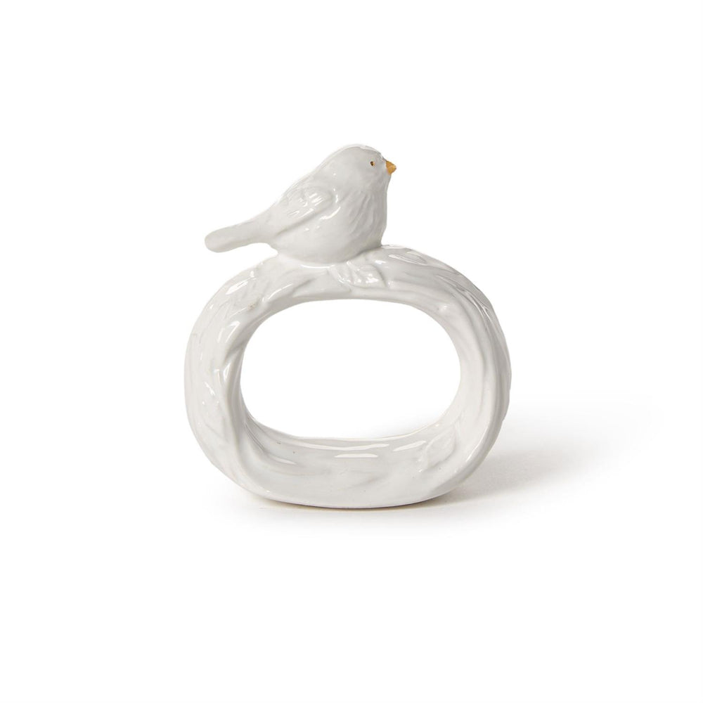 White ceramic bird perched on a branch on a white background