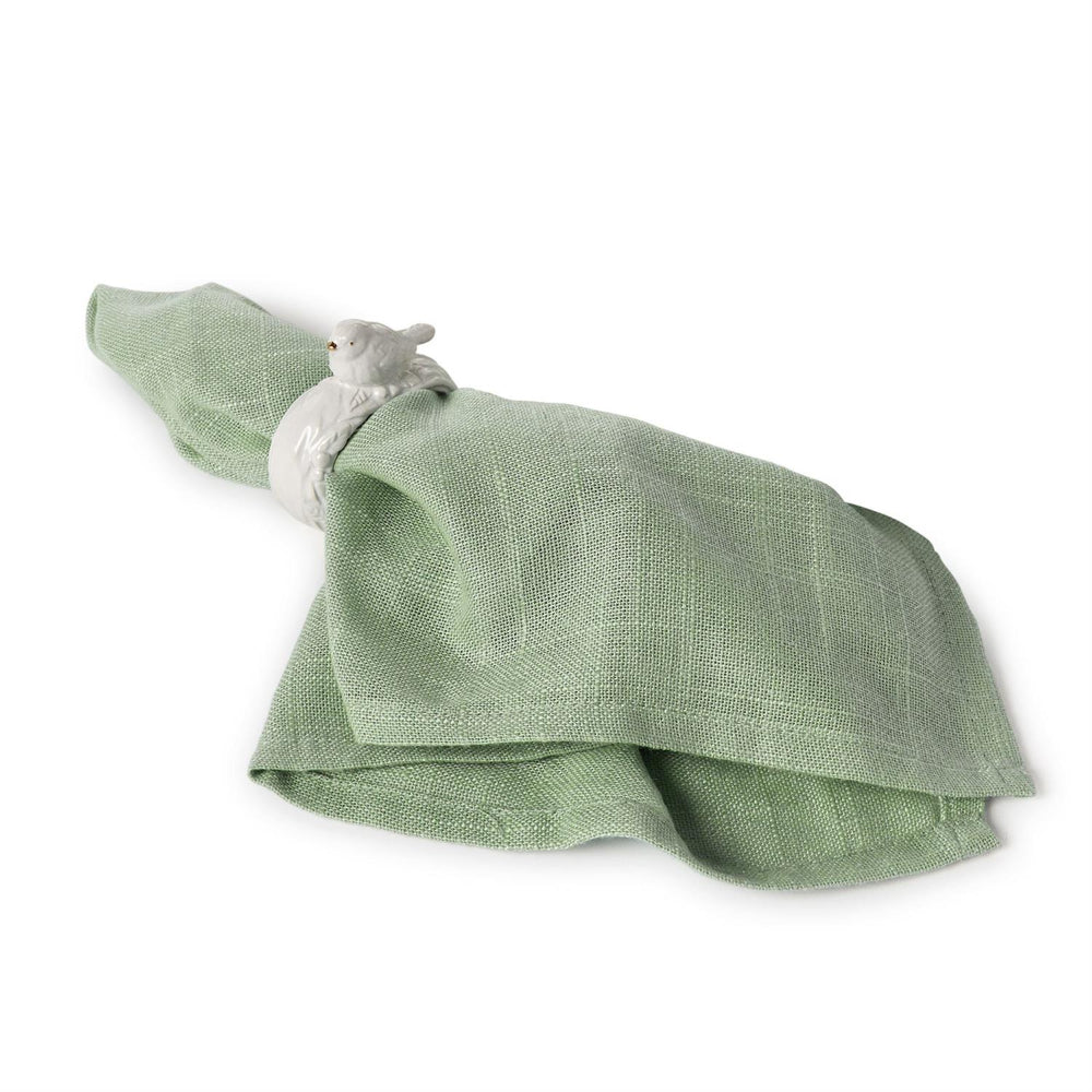 Green napkin with a decorative napkin ring with bird on a white background