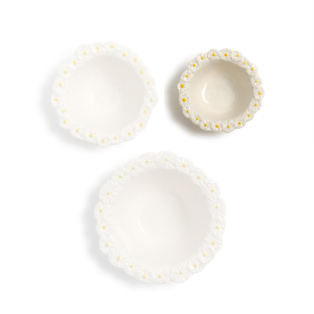 Small ceramic bowl with decorative daisy flower rims on a white background.