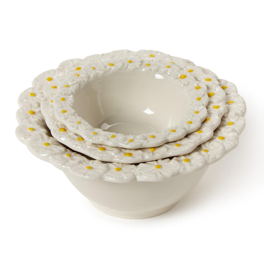 Three stacked small, medium & large ceramic bowls with decorative daisy flower rims on a white background.