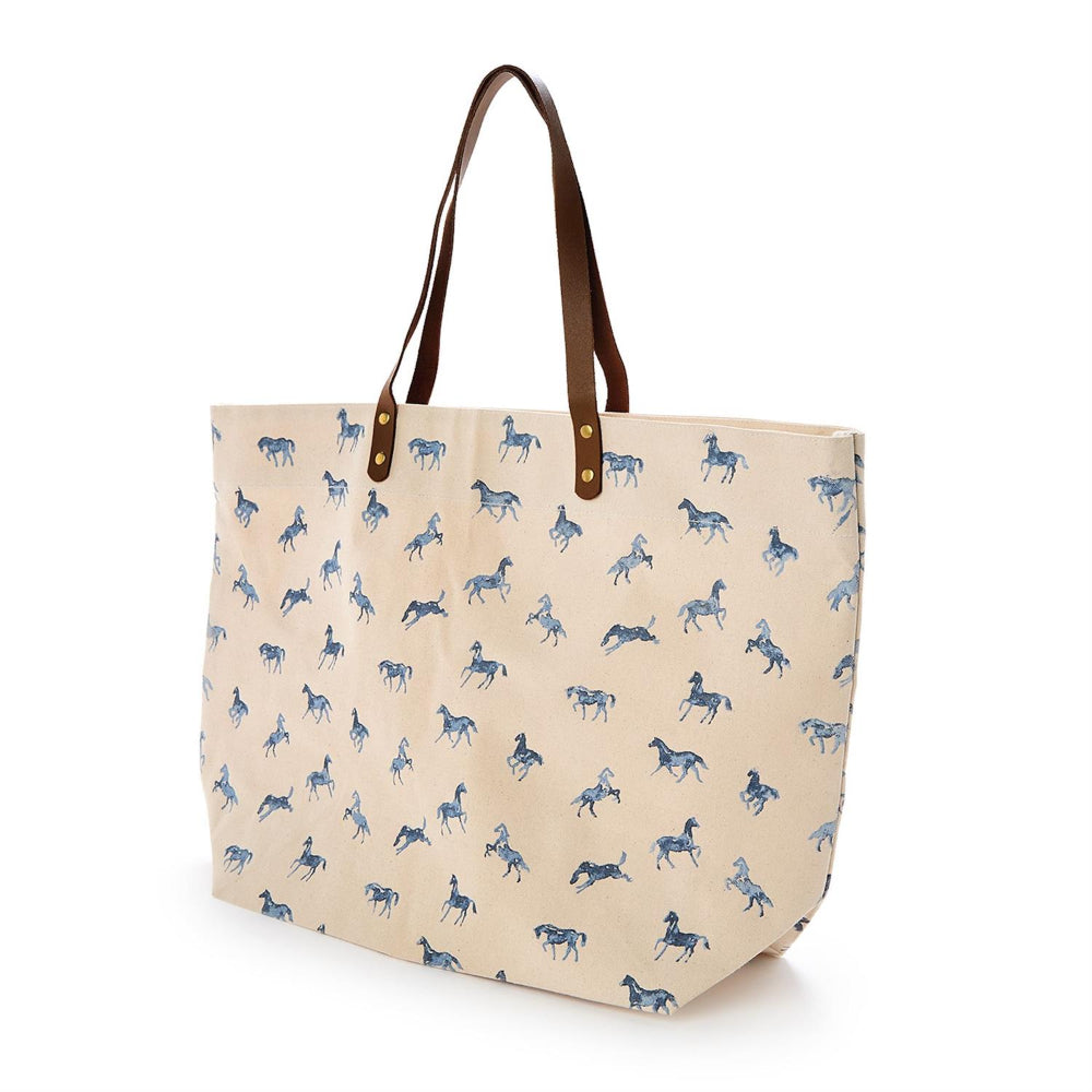 Beige tote bag with blue horse pattern and brown handles on a white background