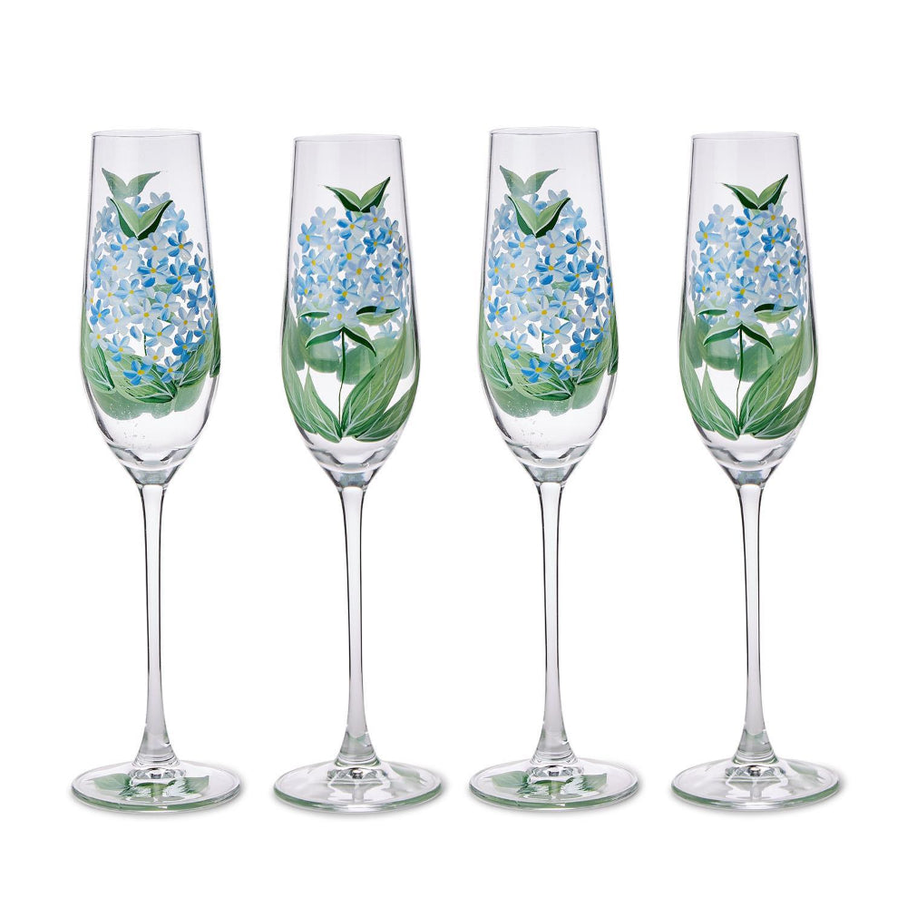 Four champagne flutes with floral designs on a white background.