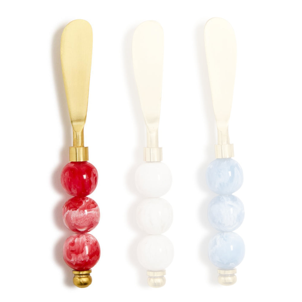 Red handled gold cheese knives with colorful red marble resin handle  on a white background