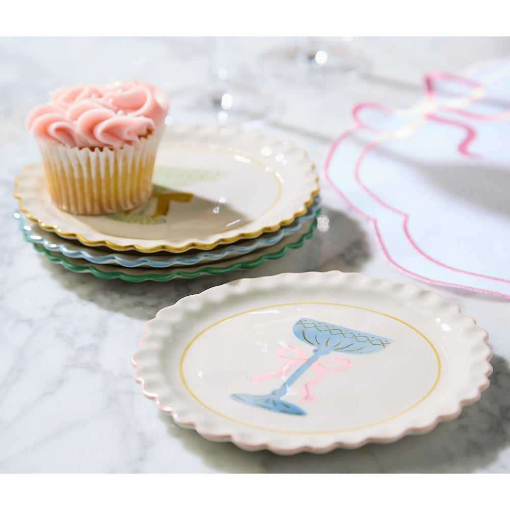 Set of decorative ceramic plates with a cupcake and cocktail design on a marble surface.