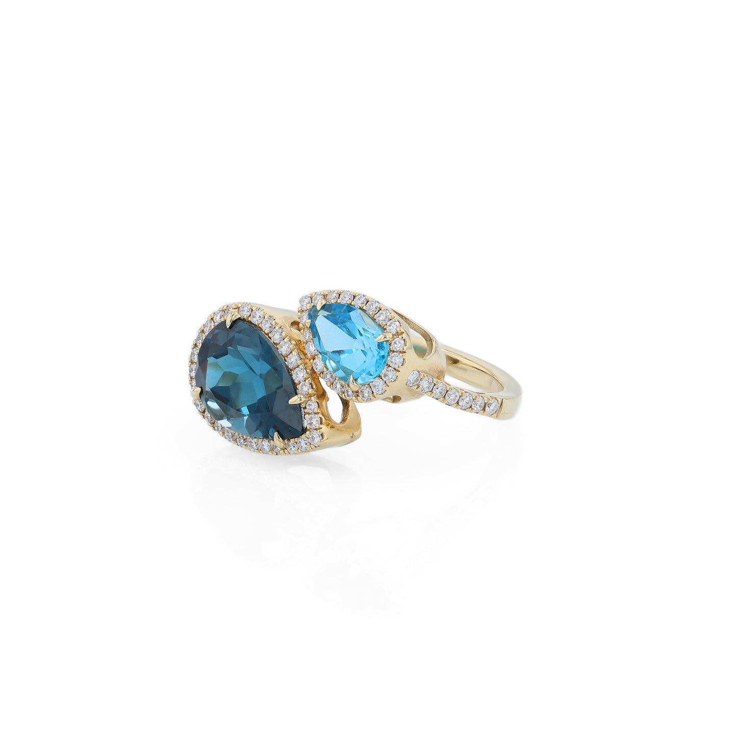 Yellow gold diamond halo bypass ring with 2 pear shape blue topaz on a white background