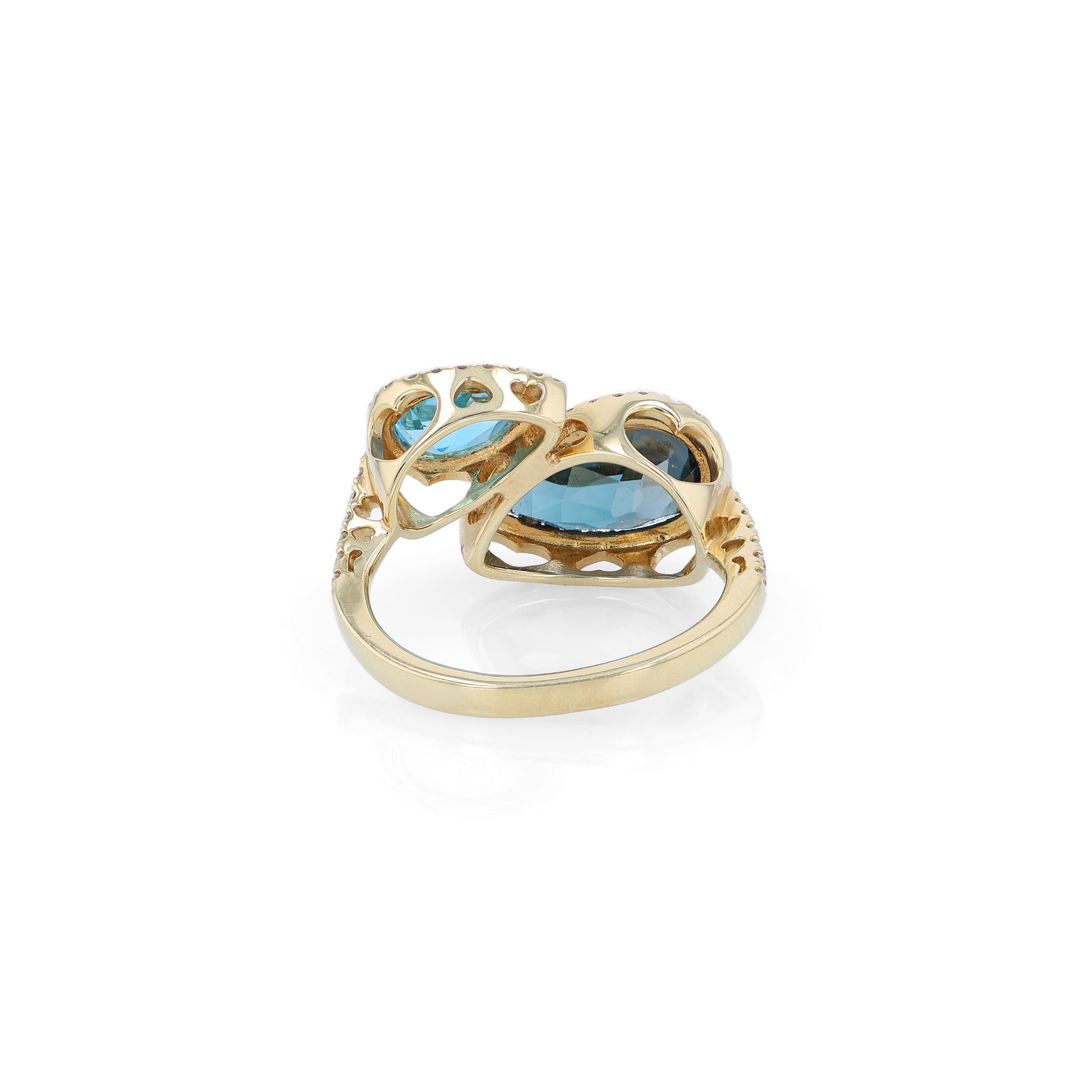 Yellow gold diamond halo bypass ring with 2 pear shape blue topaz on a white background