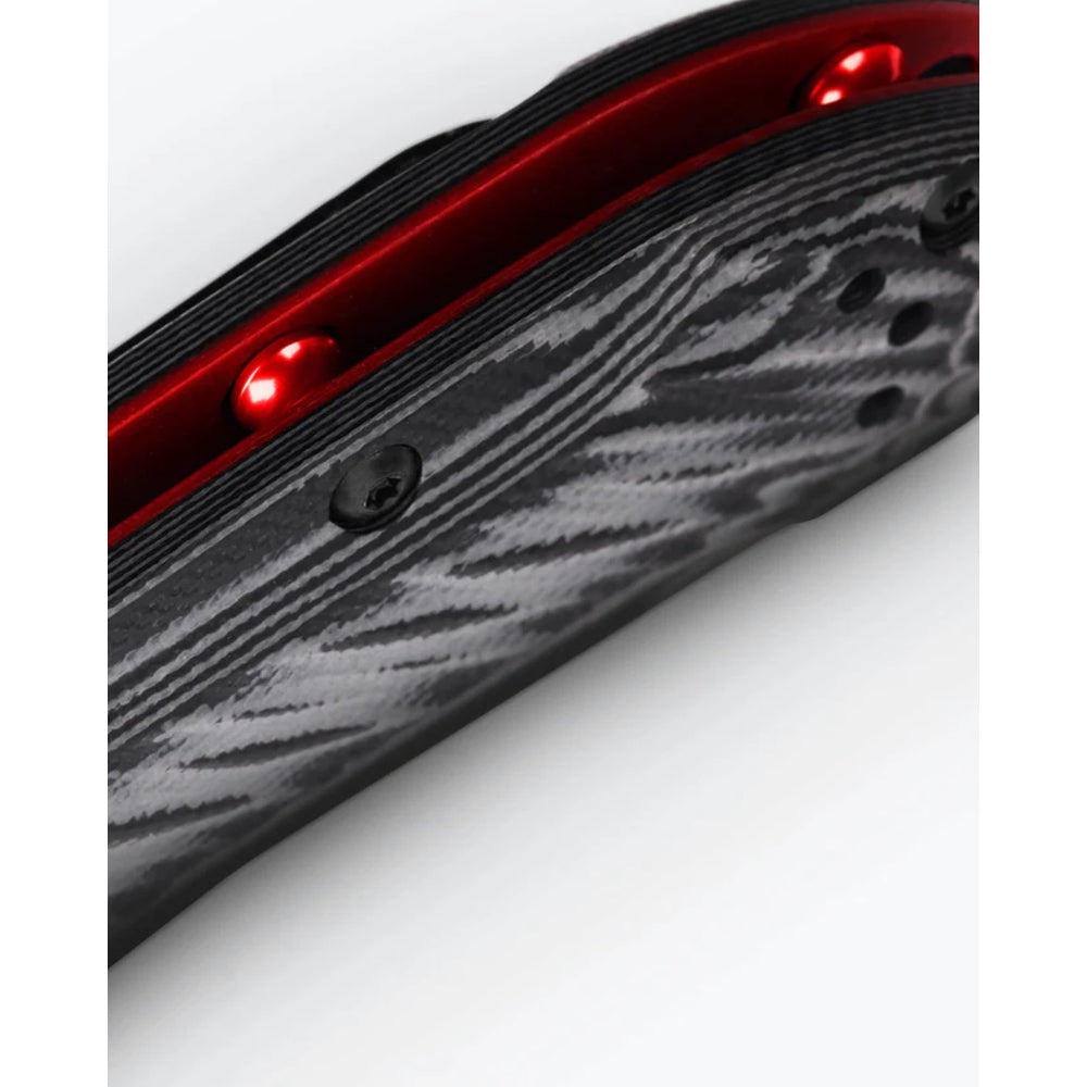 Close-up of a black and gray carbon fiber textured knife with a red metallic inner layer and glowing red LED lights, set against a plain white background.