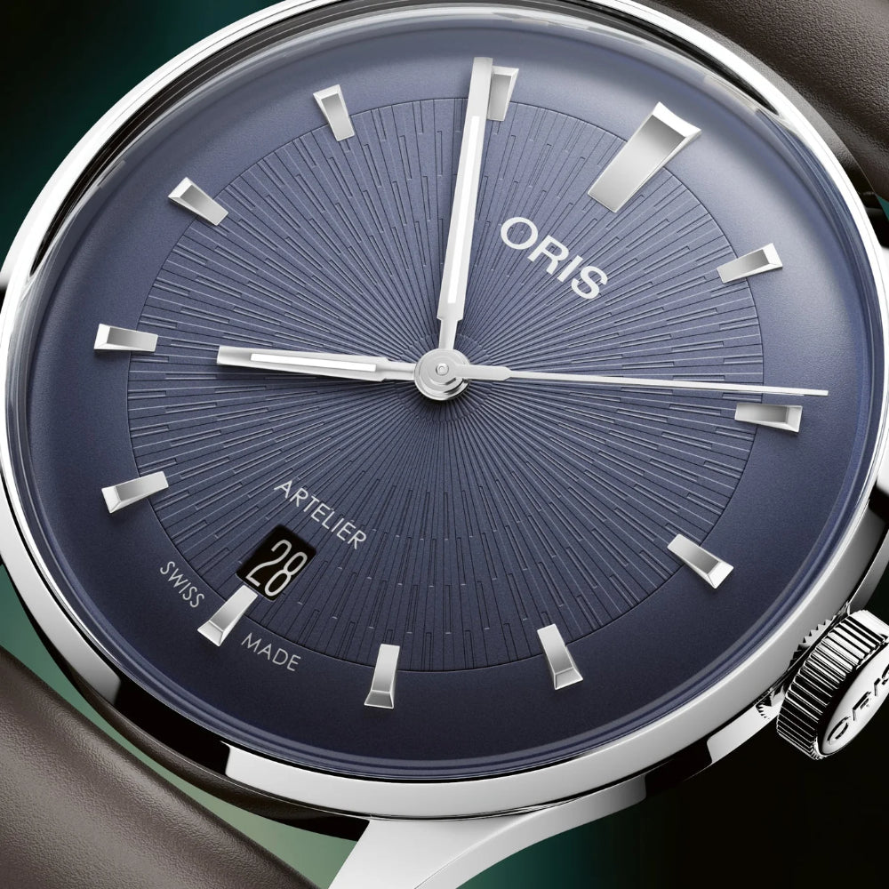 Oris watch with blue dial and silver accents on a dark background