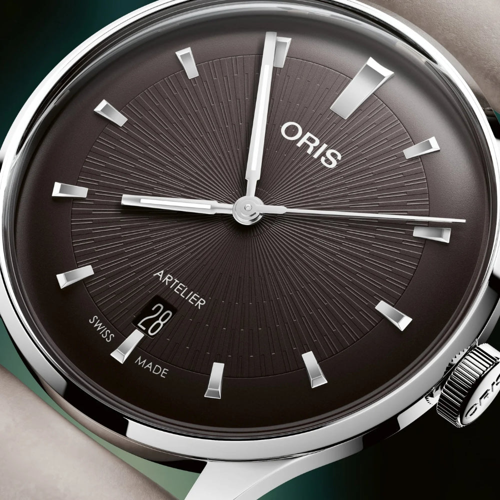 Oris watch with black dial and silver accents on a green background