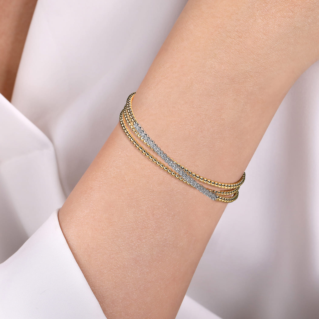 model wearing gold and silver wrap beaded bracelet with clear stones on natural background