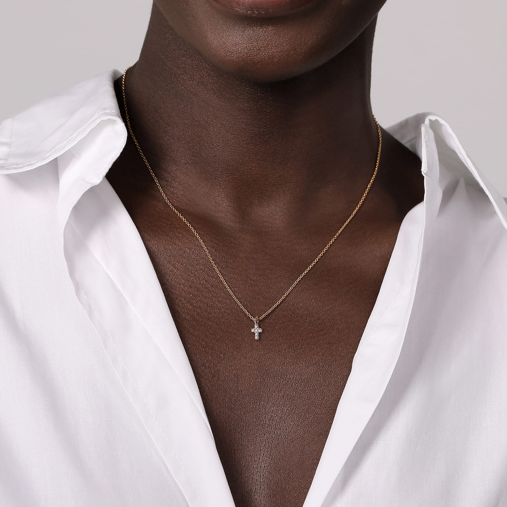 man wearing silver cross with yellow chain on white background
