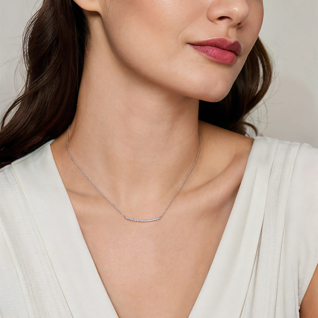 model wearing silver necklace with clear stones on natural background