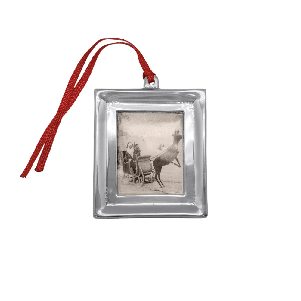 Signature photo ornament with red hanger on a white backround. 
