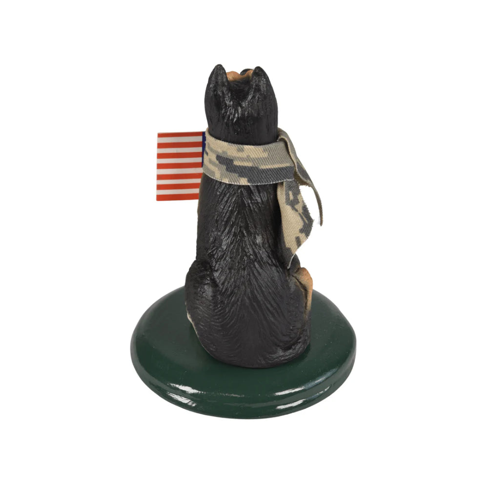 Back of a german shepard dog figurine with an american flag and camoflage bandana on a dark green base on a white background