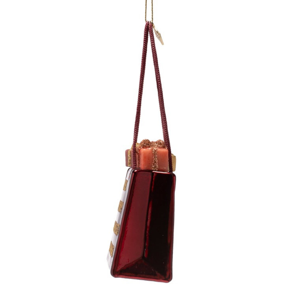 Red glass bag-shaped ornament with gold accents on a white background