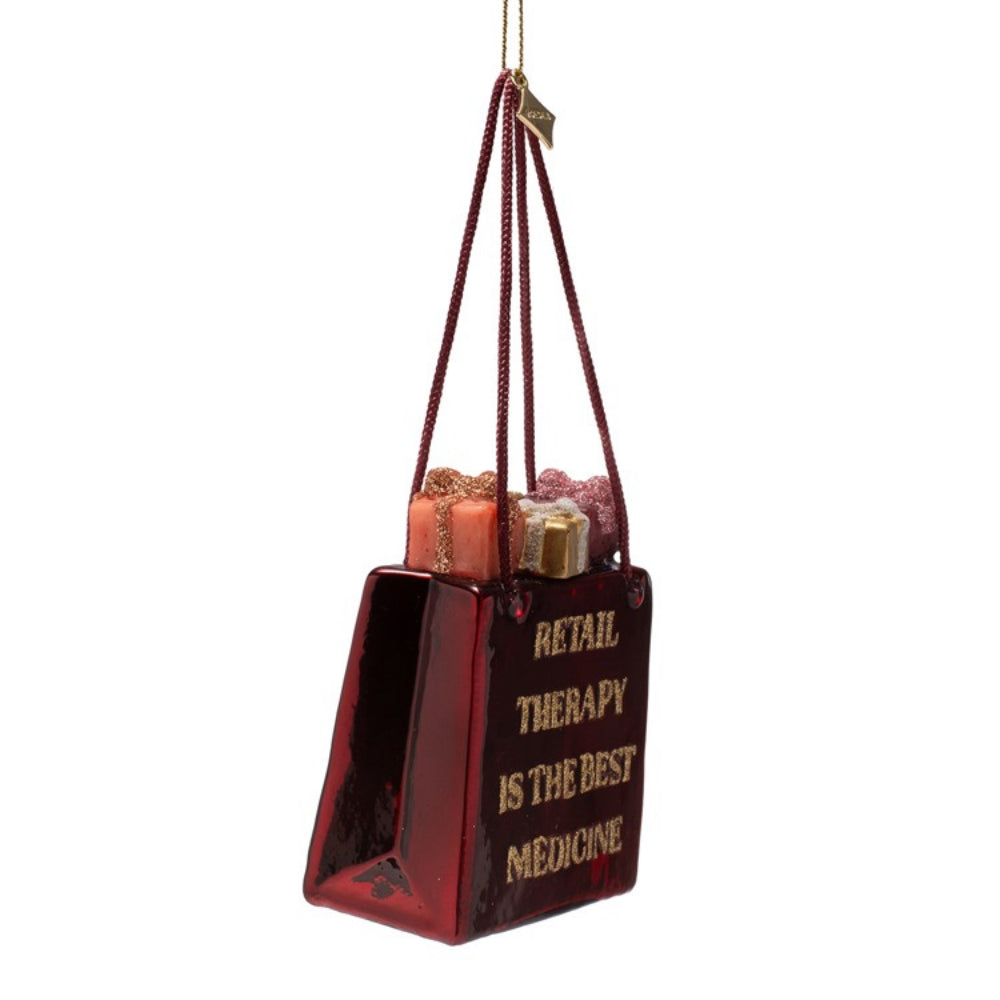 Decorative ornament shaped like a shopping bag with 'Retail Therapy is the Best Medicine' text on a white background.