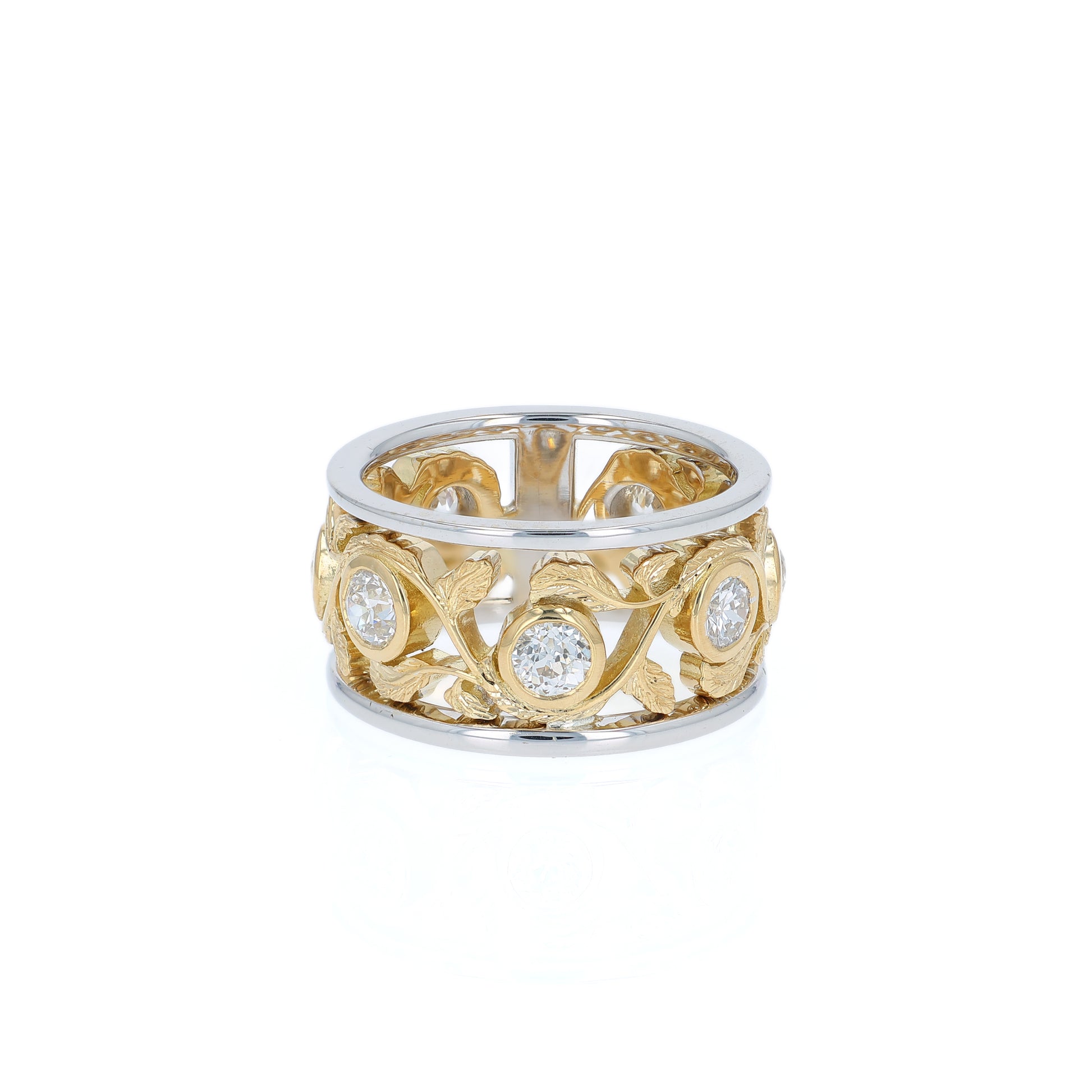Two-tone gold open work floral band with diamond bezels on a white background