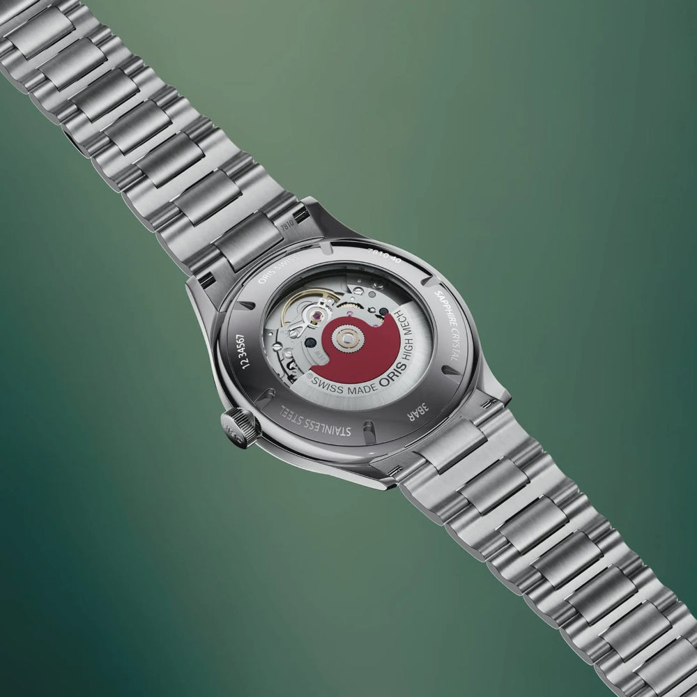 A stainless steel wristwatch with a metal link bracelet, shown from the back to reveal the transparent case and automatic mechanical movement with a red central wheel, set against a dark green gradient background.