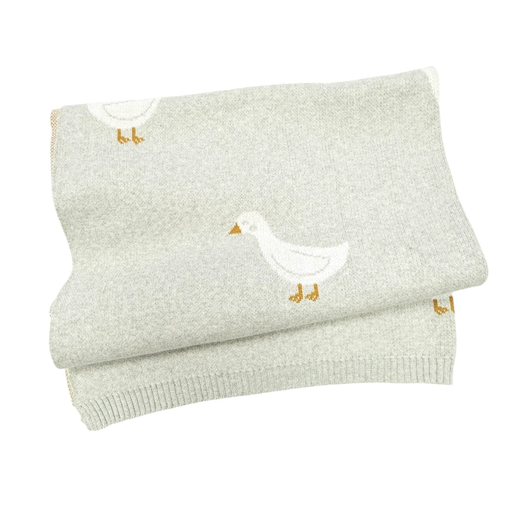 Folded light gray blanket with duck designs on a white background