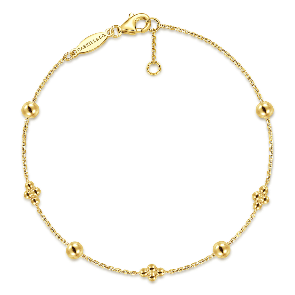 gold beaded clover bracelet on white background