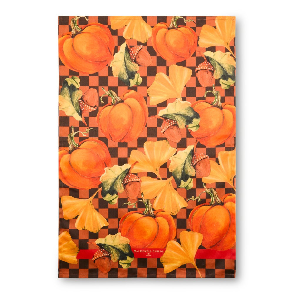 A rectangular decorative print or textile featuring a repeating autumn pattern of orange pumpkins, acorns, and orange leaves over a black-and-orange checkered background, shown against a plain white backdrop.
