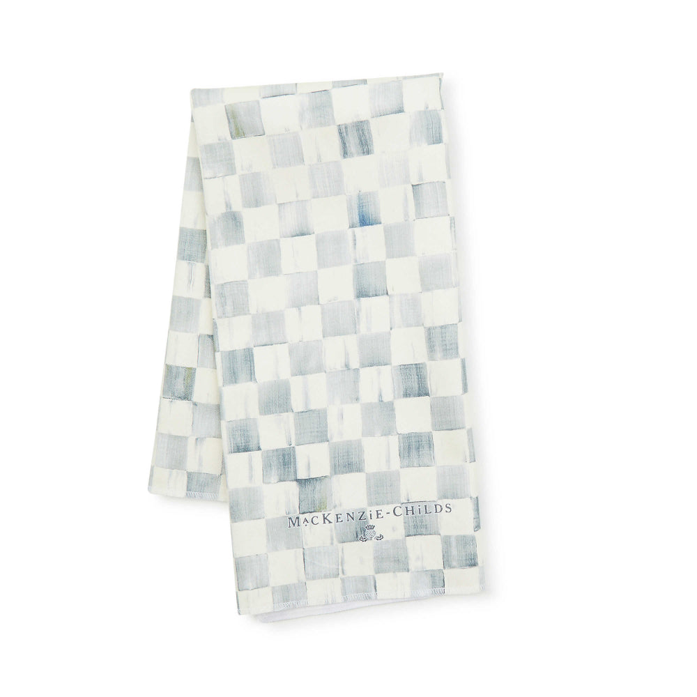 A blue and white checkered dish towel with the MacKenzie-Childs brand logo visible.