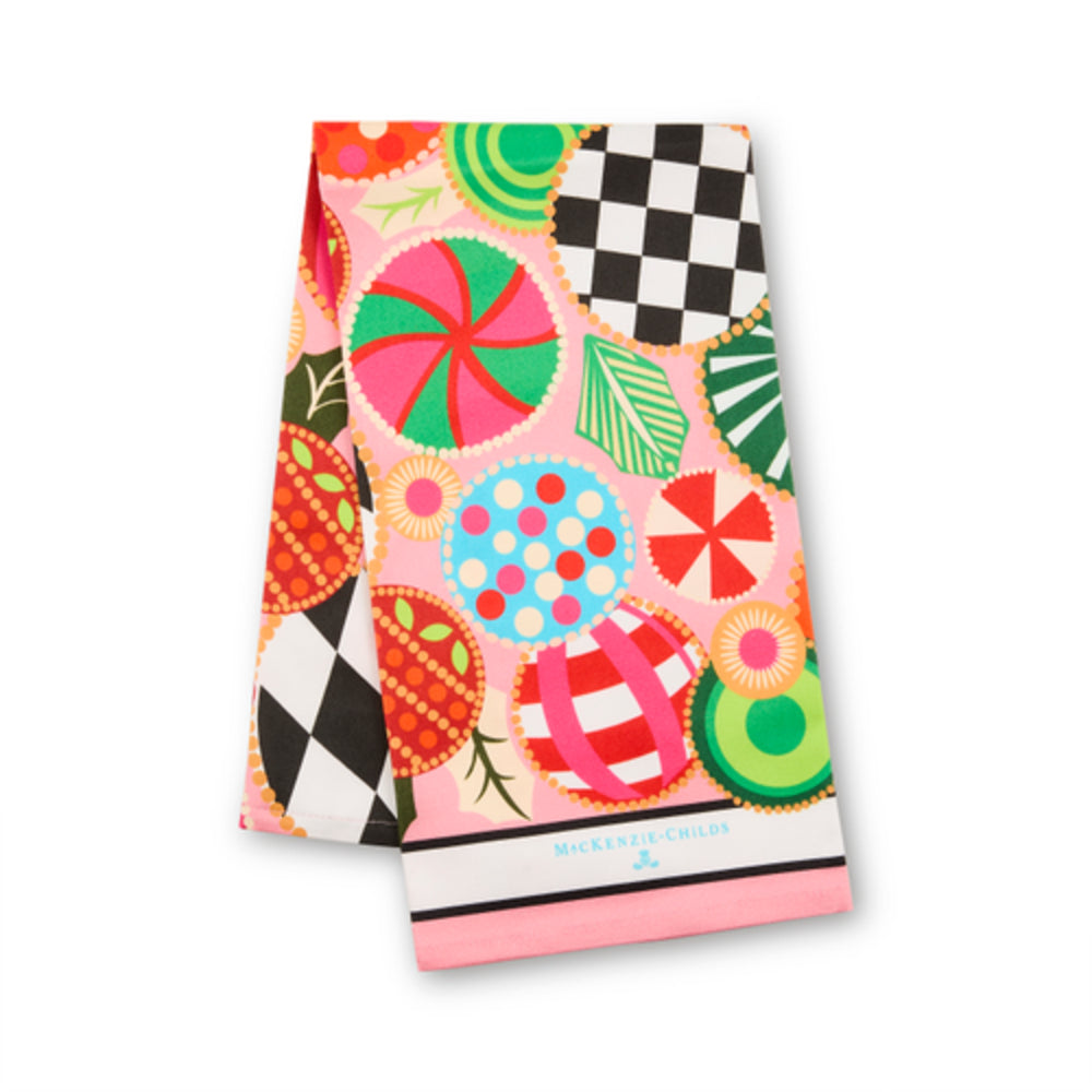 A folded kitchen towel featuring a vibrant retro candy print with pink, green, red, and black-and-white patterns, on a clean white background.
