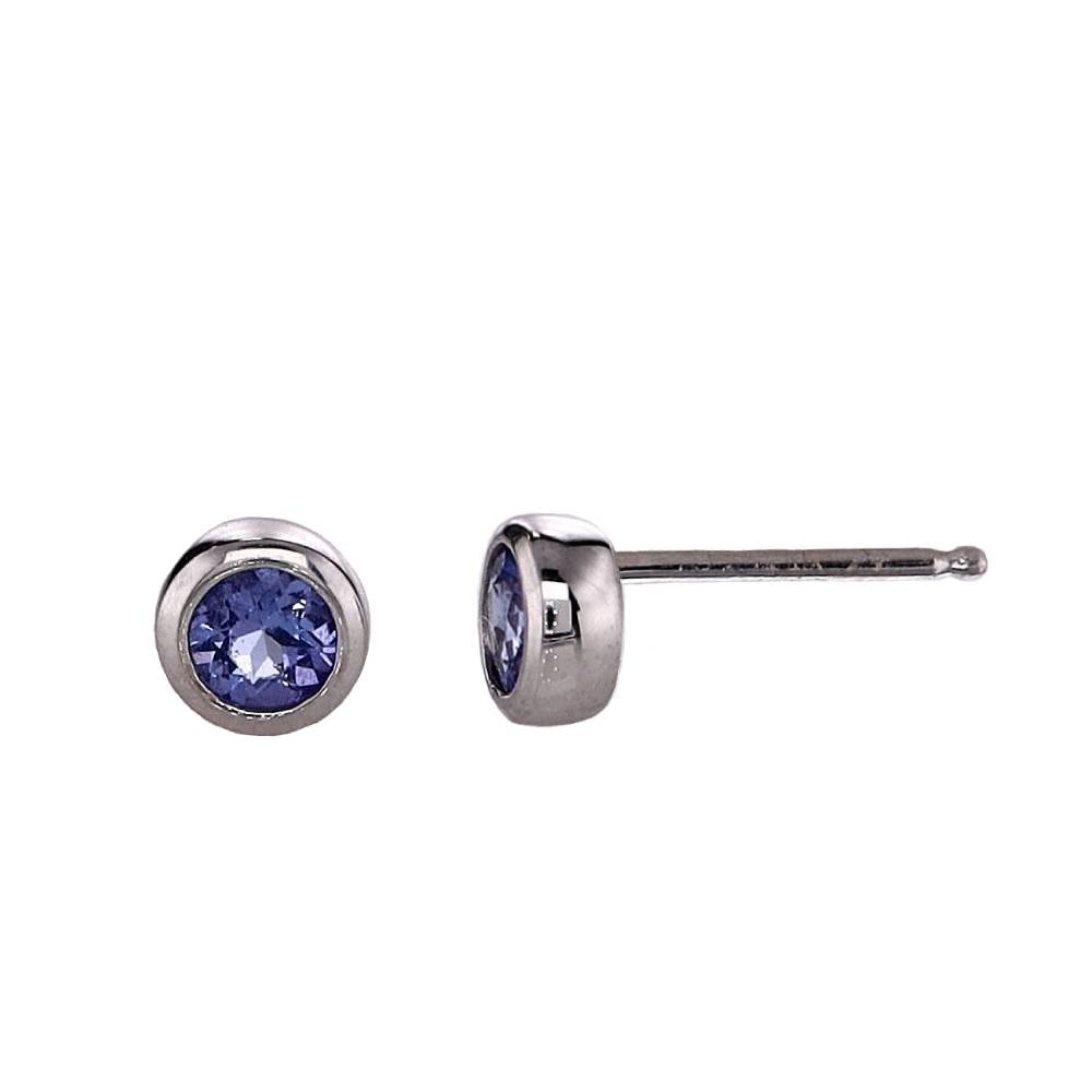 A pair of white gold round Tanzanite stud earrings with a metallic bezel on a white background
