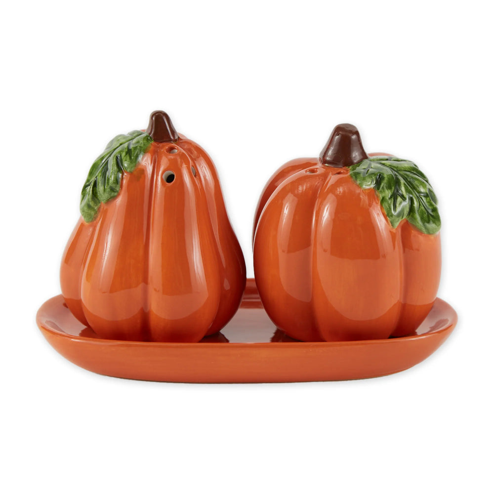 Ceramic pumpkin salt and pepper shakers on a matching tray with a white background