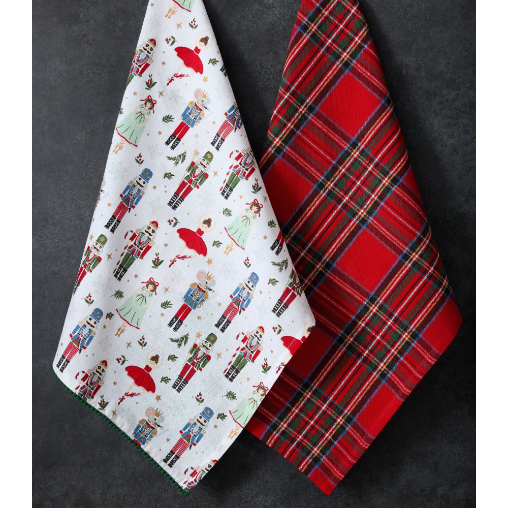 Two Christmas-themed towels, one with nutcracker design and the other with plaid pattern, on a dark background.