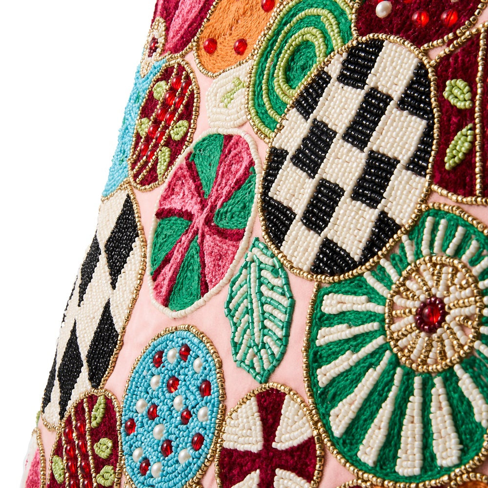 Close-up of a pink garment featuring large embroidered Easter egg motifs in black, white, green, red, blue, and gold beadwork.