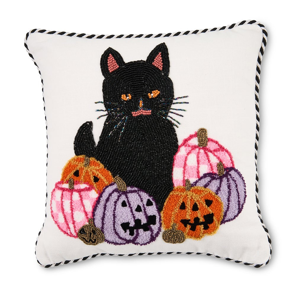 A square white decorative pillow with a black-and-white braided edge and a central embroidered design of a black cat surrounded by pink, orange, and purple jack-o'-lantern pumpkins.