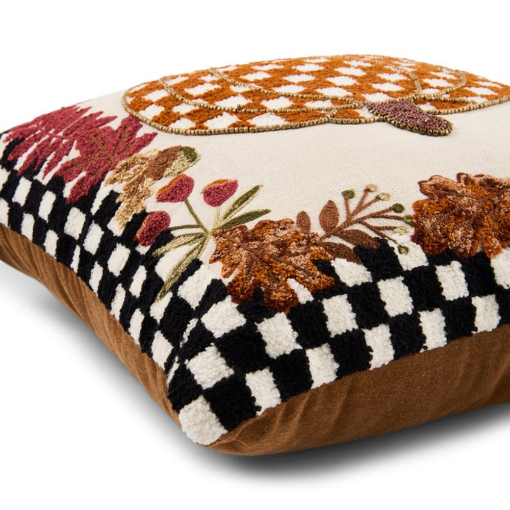 A square decorative throw pillow with a cream background, featuring a black and white checkered border, a brown suede-like side, and autumn-themed embroidery including orange leaves, red berries, and a peach-colored fish motif on top.