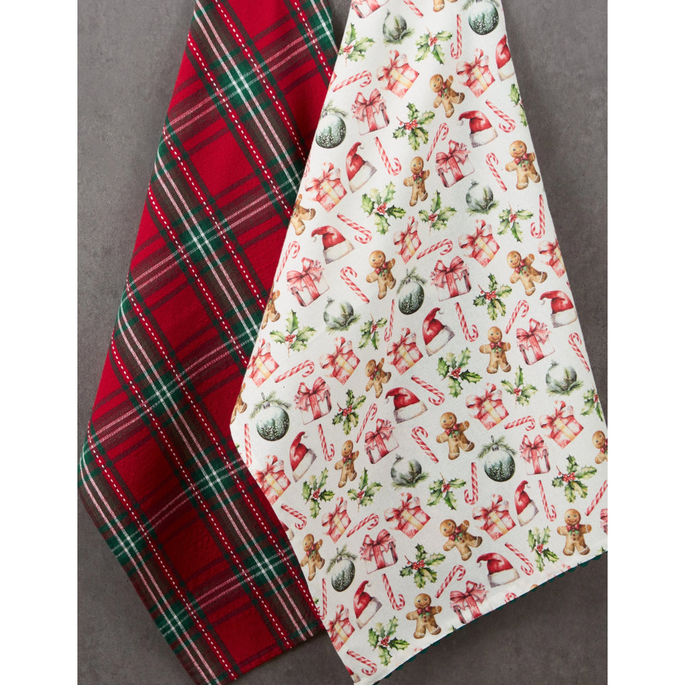 Two Christmas-themed fabric items, likely tea towels or napkins, displayed diagonally on a gray background. One features a classic red, green, and white plaid pattern, and the other has a white background printed with festive illustrations of gingerbread men, candy canes, ornaments, and gifts.