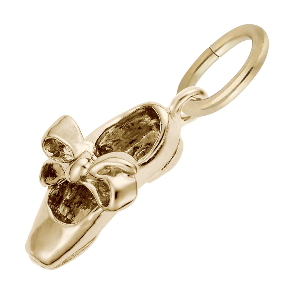 A polished gold charm shaped like a tap shoe with a bow detail, shown on a plain white background.