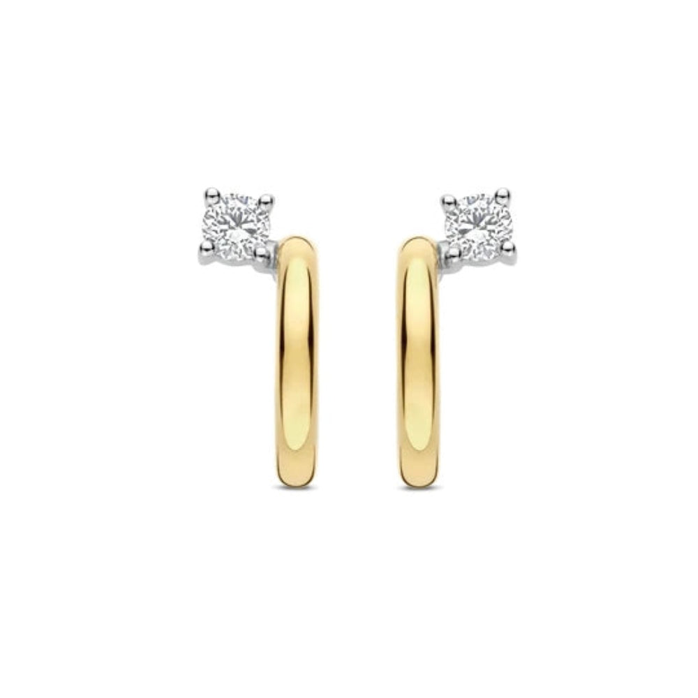 A pair of gold and silver huggie hoop earrings, each featuring a small square-cut clear gemstone in a prong setting, shown against a plain white background.