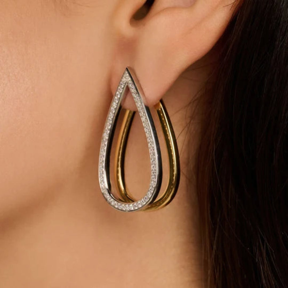 woman wearing tear drop shaped earrings - the front is set with cubic zirconia stones and the rear teardrop is gold tone