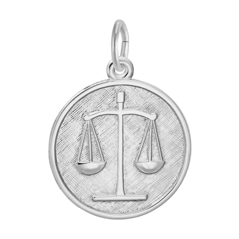 Silver disc charm with the scales of justice inscribed upon it, shown on a white background