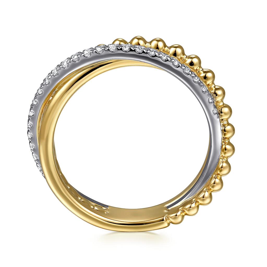gold and silver ring with clear stones on white background from side