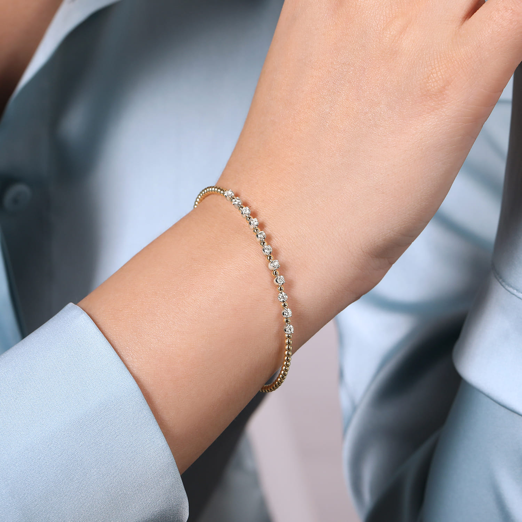 model wearing yellow bracelet with clear stone stations 