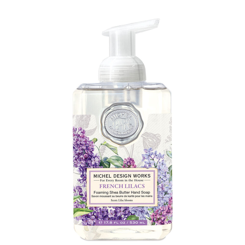 A clear foaming soap dispenser with a pump, decorated with a purple floral pattern and labeled 'Michel Design Works French Lilacs'.