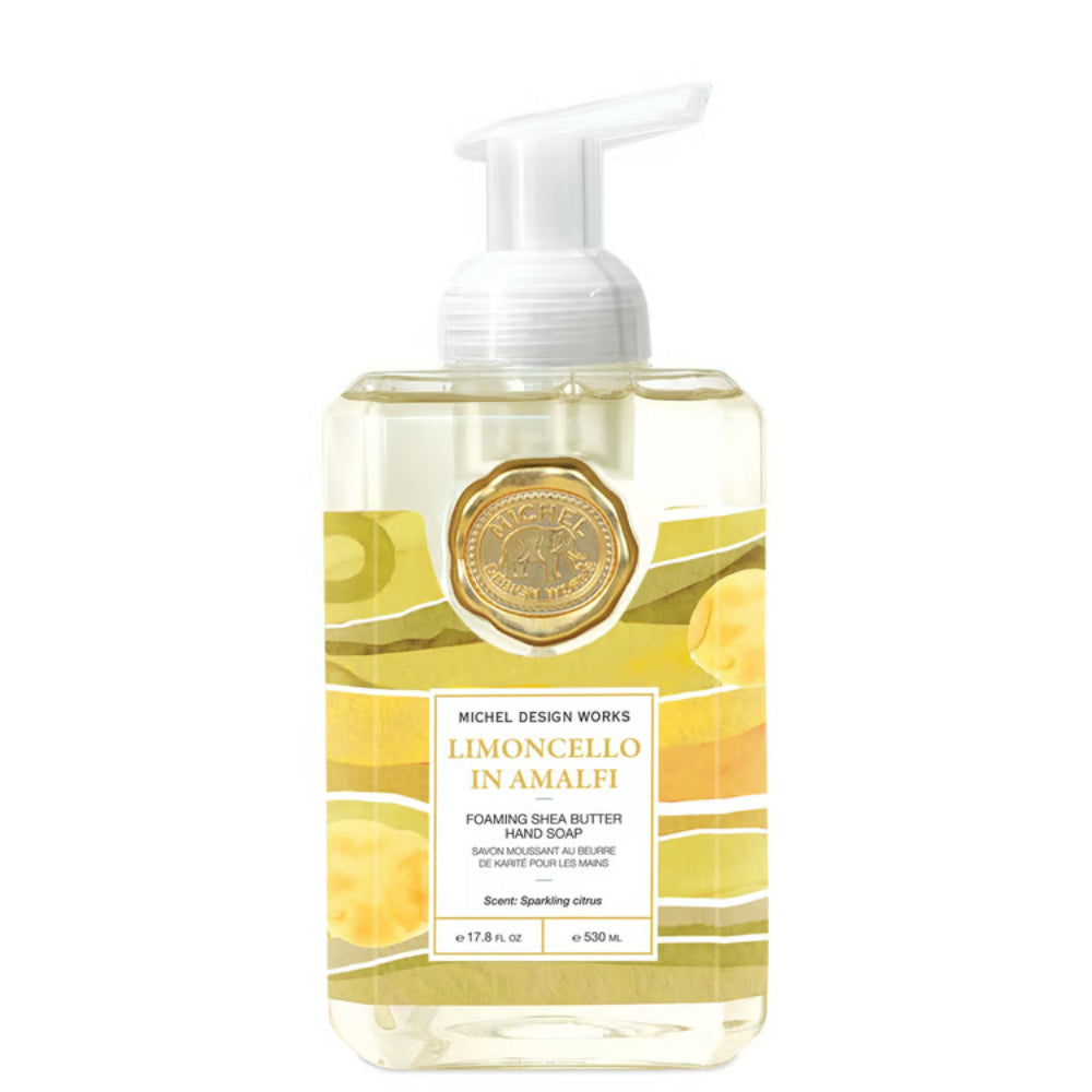 Michel Design Works Limoncello in Amalfi foaming shea butter hand soap in a clear rectangular bottle with a white pump dispenser, featuring yellow-green graphic patterns and a gold circular emblem on a white background.