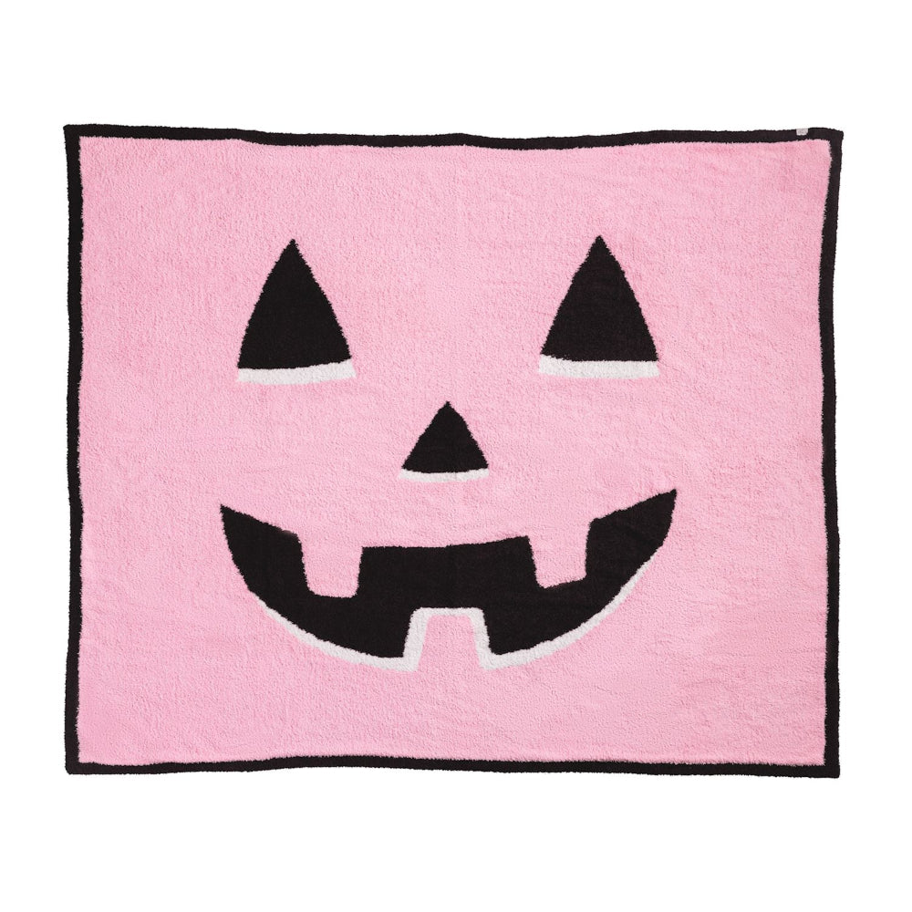 Pink blanket with a black jack-o'-lantern face design on a white background