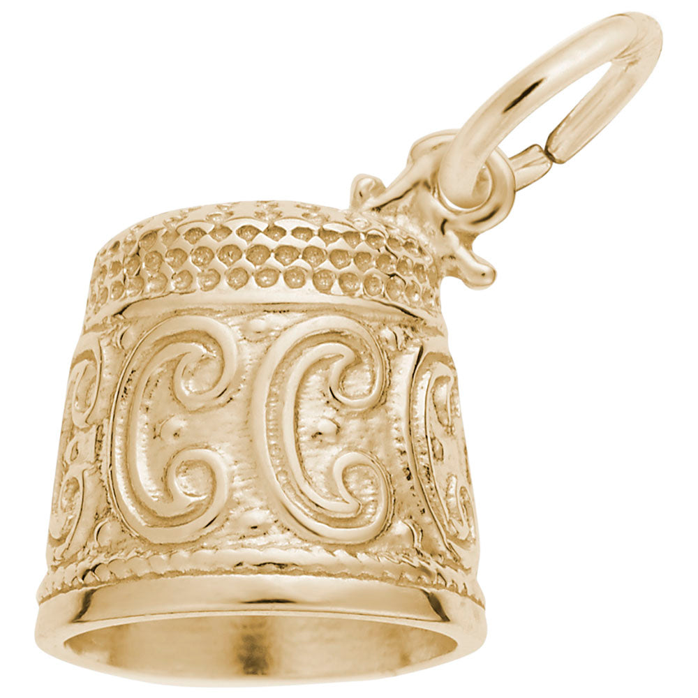 Gold thimble charm with intricate designs on a white background