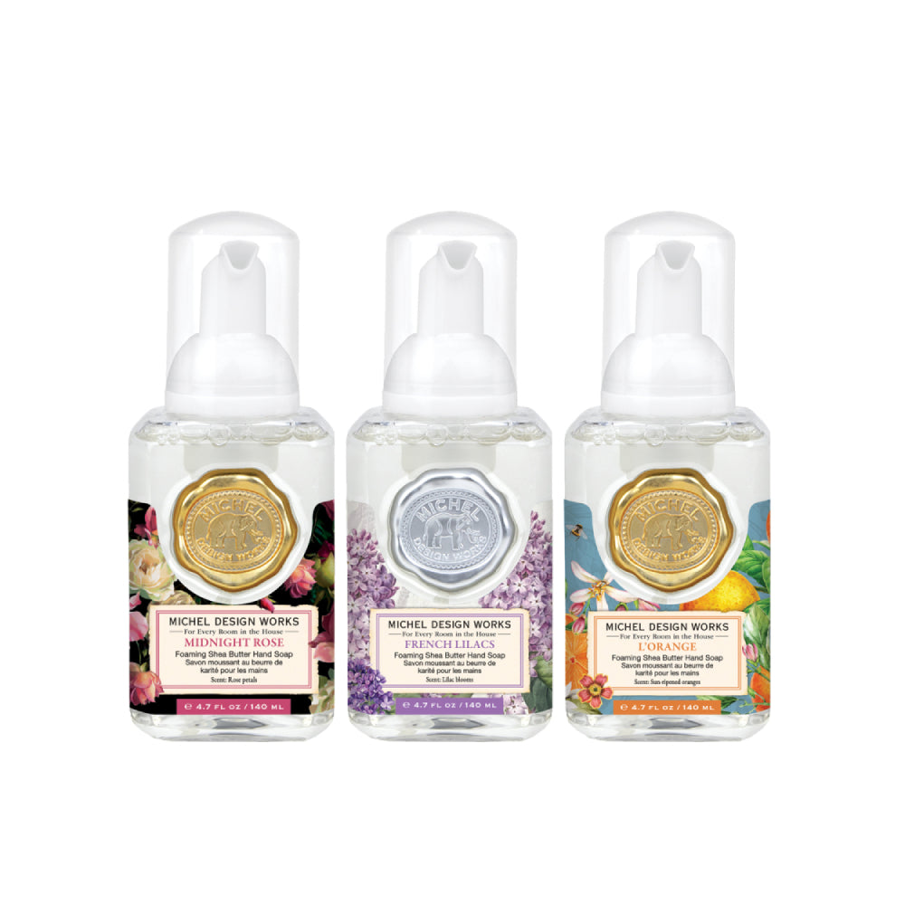 Three colorful bottles of Michel Design Works hand soaps with different scents on a white background.