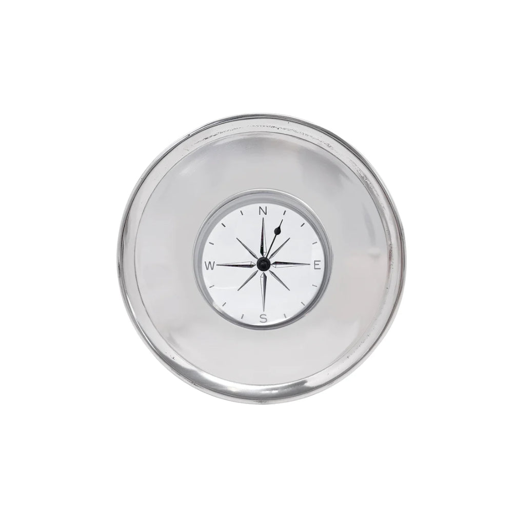 A round clear plastic or acrylic compass with a silver-toned rim and a white dial showing cardinal directions N, W, S, E.